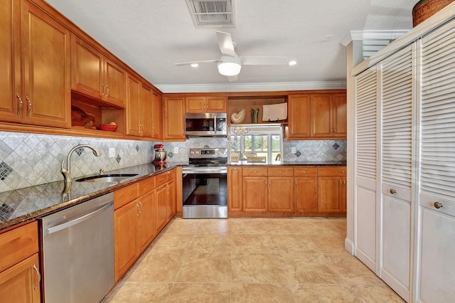 kitchen featuring sink, dark stone countertops, ceiling fan, stainless steel appliances, and decorative backsplash