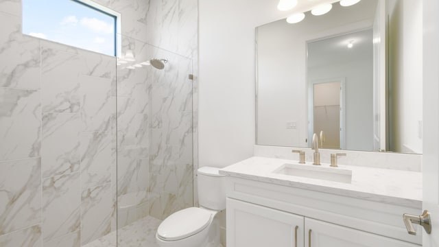 bathroom featuring vanity, toilet, and tiled shower