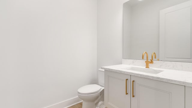 bathroom featuring vanity, hardwood / wood-style floors, and toilet