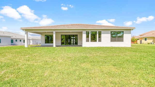 rear view of house featuring a yard