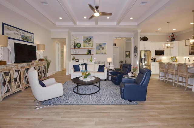 living room featuring beamed ceiling, ceiling fan, ornamental molding, and sink