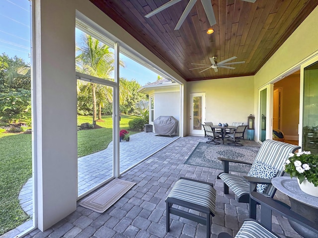 sunroom featuring wood ceiling and ceiling fan