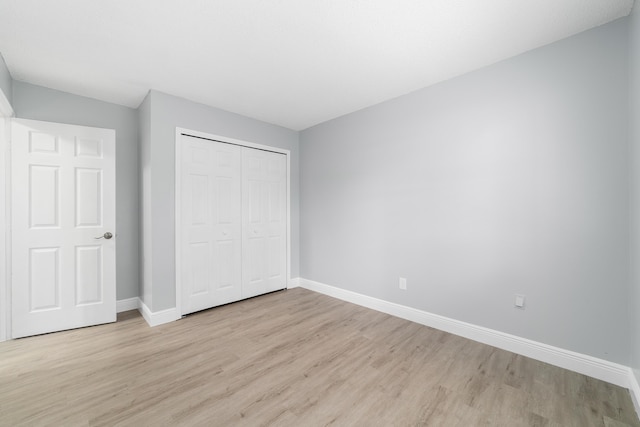 unfurnished bedroom featuring light hardwood / wood-style floors and a closet