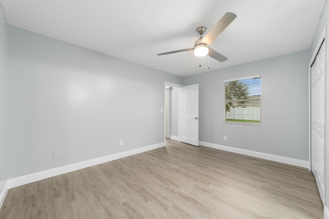 unfurnished bedroom with a closet, a textured ceiling, ceiling fan, and light hardwood / wood-style flooring