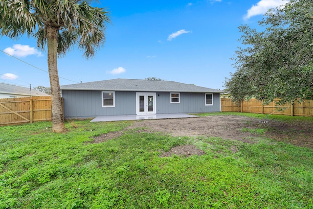 rear view of property featuring a yard, a patio area, and french doors