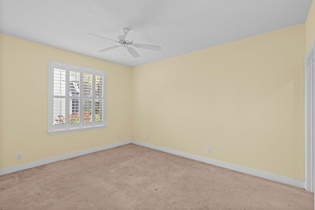 unfurnished room with ceiling fan, light carpet, and a textured ceiling