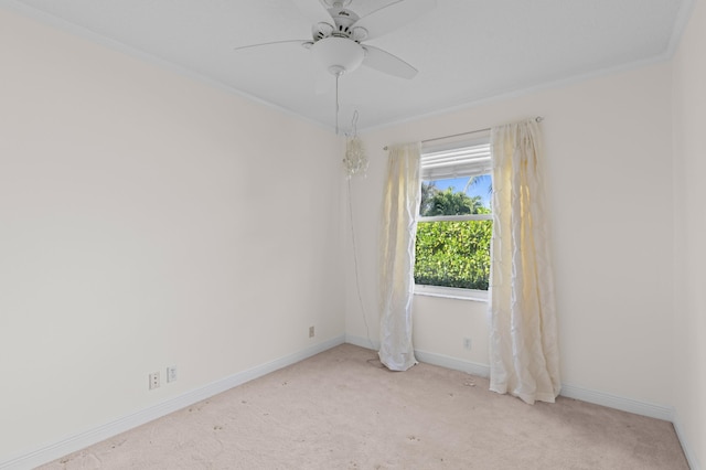 unfurnished room with ornamental molding, light colored carpet, and ceiling fan