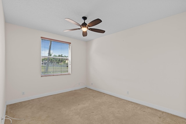 unfurnished room with ceiling fan, light carpet, and a textured ceiling