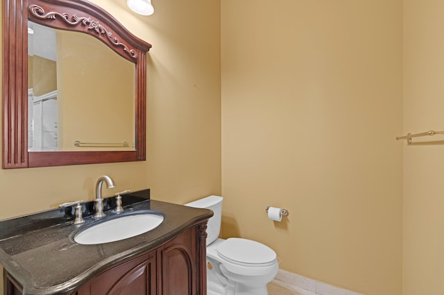 bathroom featuring tile patterned flooring, vanity, and toilet