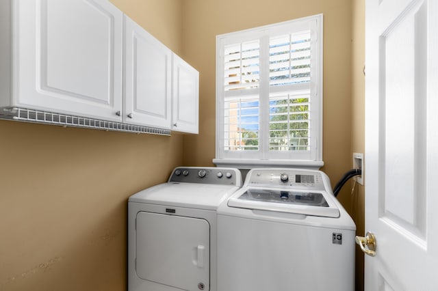 laundry room featuring cabinets and separate washer and dryer