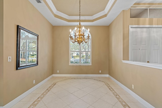 tiled spare room with crown molding, a notable chandelier, a tray ceiling, and a healthy amount of sunlight