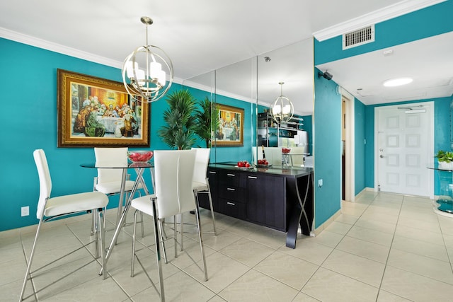 kitchen featuring pendant lighting, a notable chandelier, crown molding, and light tile patterned floors