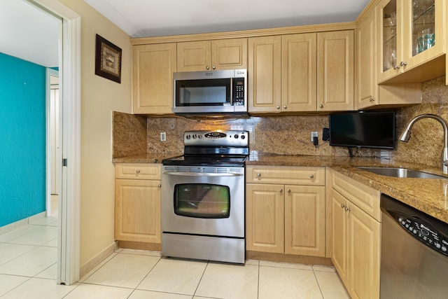 kitchen with sink, appliances with stainless steel finishes, light stone countertops, light tile patterned flooring, and light brown cabinets