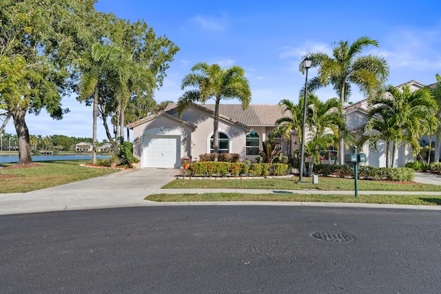 view of front of property with a water view, a garage, and a front lawn