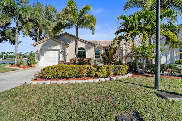 view of front of property featuring a garage, a front yard, and a water view