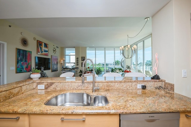 kitchen with light stone counters, sink, and stainless steel dishwasher