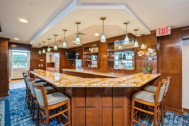 bar featuring pendant lighting and light stone countertops