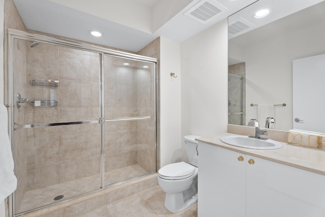 bathroom with tile patterned flooring, vanity, a shower with door, and toilet