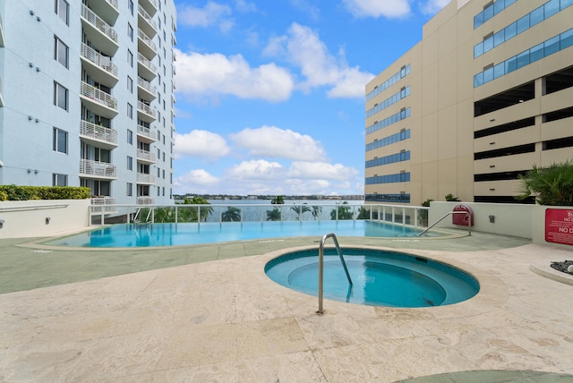 view of swimming pool with a hot tub