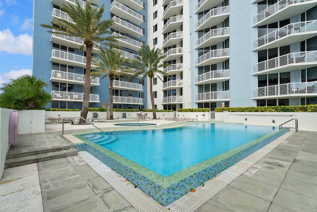 view of pool with a hot tub and a patio area