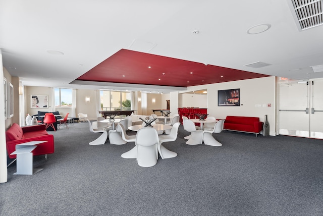 interior space featuring a tray ceiling and carpet flooring