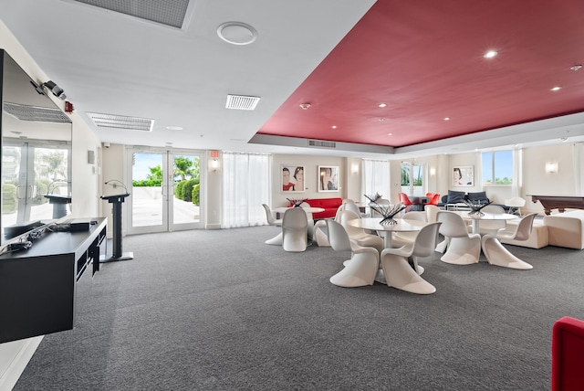 exercise room with carpet flooring, a tray ceiling, and french doors