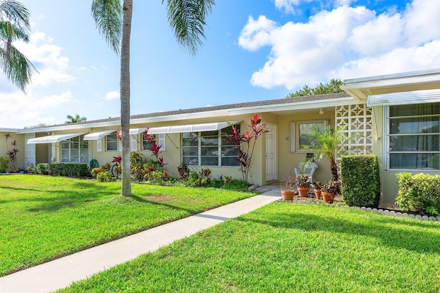 180 High Point Ter E Unit C, Delray Beach, FL 33445 - view of front of home with stucco siding and a front lawn