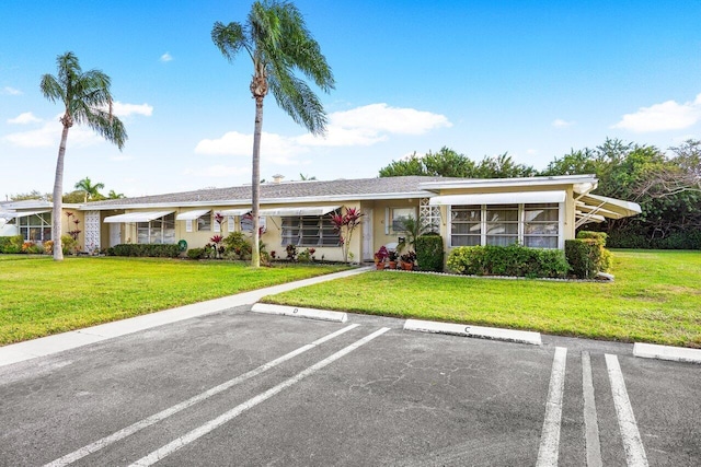 180 High Point Ter E Unit C, Delray Beach, FL 33445 - view of front of property featuring uncovered parking and a front yard