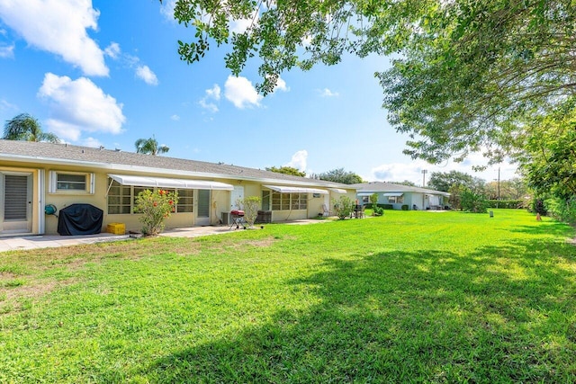 180 High Point Ter E Unit C, Delray Beach, FL 33445 - back of property featuring a patio area, a yard, and stucco siding