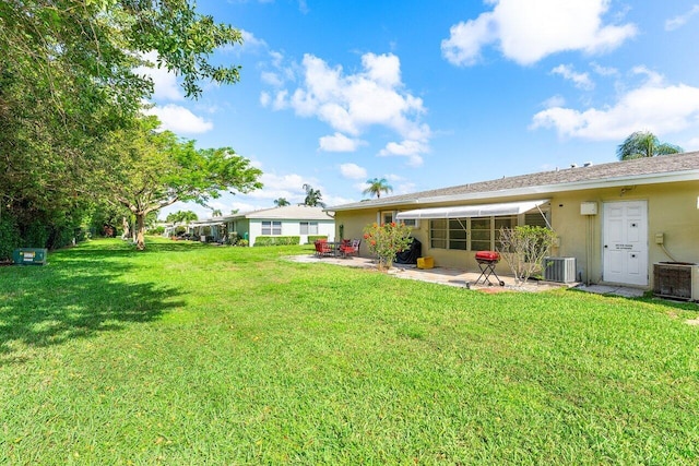180 High Point Ter E Unit C, Delray Beach, FL 33445 - rear view of house featuring a patio area, central AC unit, a lawn, and stucco siding