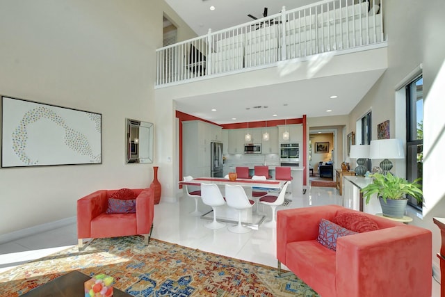 living room with a towering ceiling and light tile patterned floors