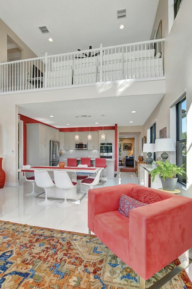 living room featuring tile patterned flooring and a towering ceiling