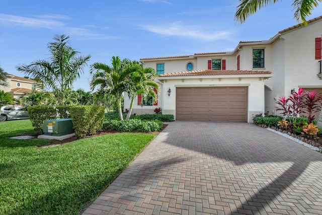 mediterranean / spanish-style house featuring a garage and a front lawn