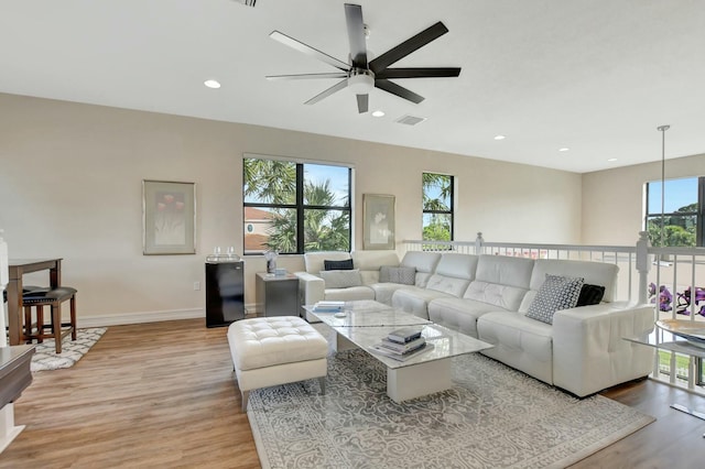 living room featuring ceiling fan and light hardwood / wood-style floors