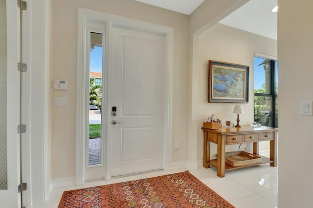 foyer entrance with light tile patterned flooring and a healthy amount of sunlight