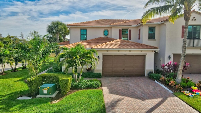 mediterranean / spanish house featuring a garage and a front yard