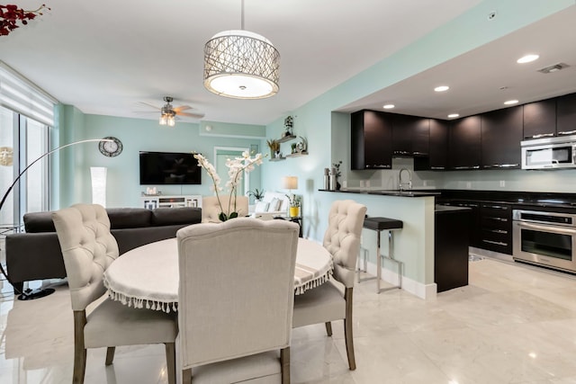 dining area with sink and ceiling fan