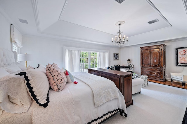 bedroom featuring a raised ceiling and a chandelier