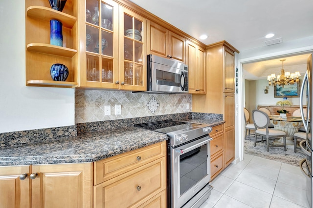 kitchen featuring tasteful backsplash, a chandelier, hanging light fixtures, dark stone countertops, and stainless steel appliances