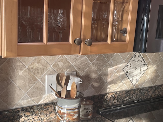 interior details featuring dark stone counters and decorative backsplash