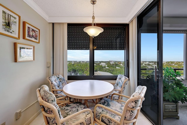 dining room featuring ornamental molding, light tile patterned floors, and a textured ceiling