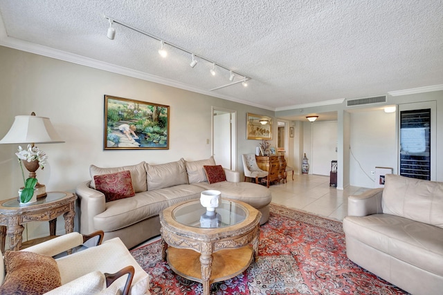 living room with light tile patterned floors, track lighting, ornamental molding, and a textured ceiling