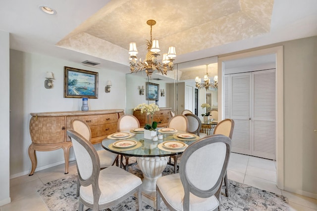 dining room with an inviting chandelier, light tile patterned floors, and a raised ceiling