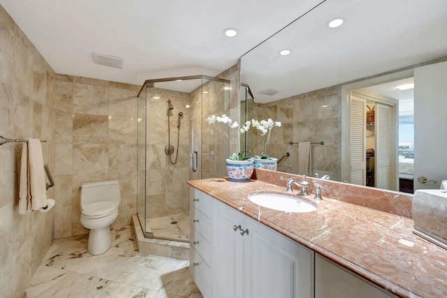 bathroom featuring vanity, toilet, tile walls, and walk in shower