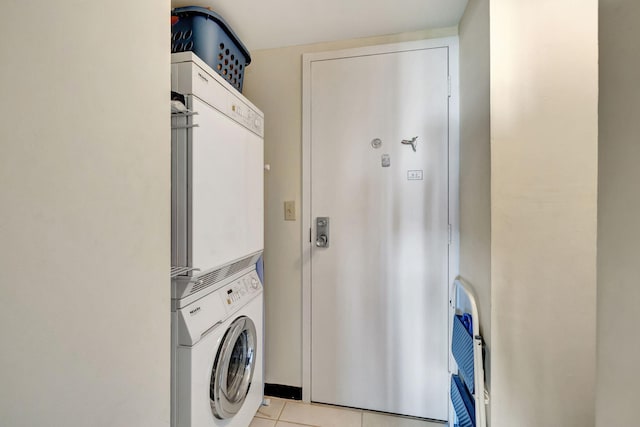 laundry area featuring stacked washing maching and dryer and light tile patterned floors