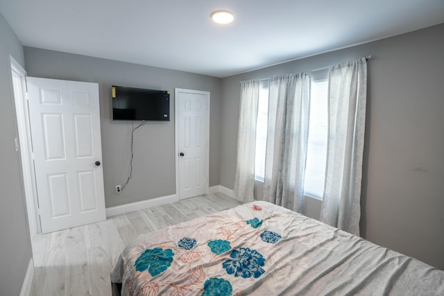 bedroom with multiple windows and light wood-type flooring