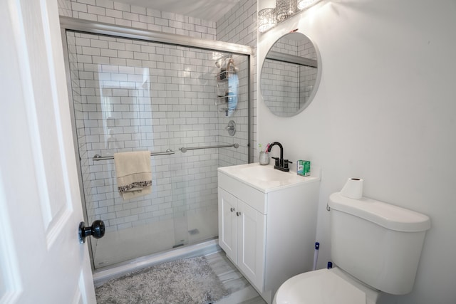 bathroom with vanity, toilet, and a shower with shower door