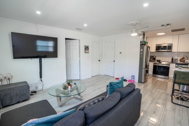 living room featuring ceiling fan and light hardwood / wood-style flooring