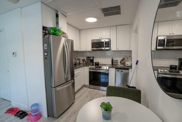 kitchen with white cabinetry, appliances with stainless steel finishes, and decorative backsplash