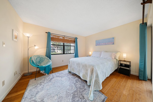 bedroom with baseboards and wood finished floors